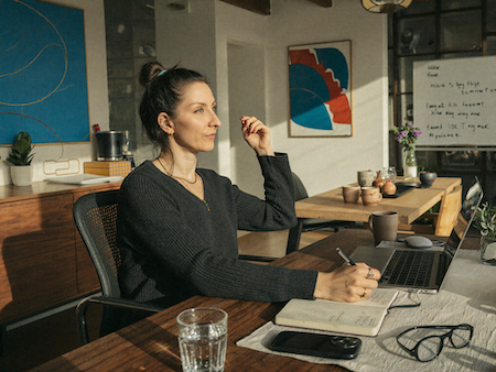 Astrid Dietrich am Schreibtisch in der Abendstunde, am Laptop arbeitend — als sie selbst noch in der Burnout-Spirale steckte