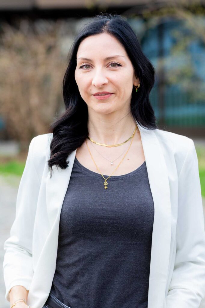 Astrid Dietrich — Mental Load und Burnout Coach, Portrait in deep teal am modernen Home-Office-Schreibtisch