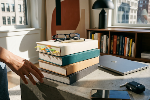 Stapel Selbsthilfe-Bücher mit Lesebrille und geschlossenem Laptop — die üblichen Lösungen reichen nicht