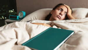 Frau wach im Bett mit Gedankenkarussell - Nachtszene